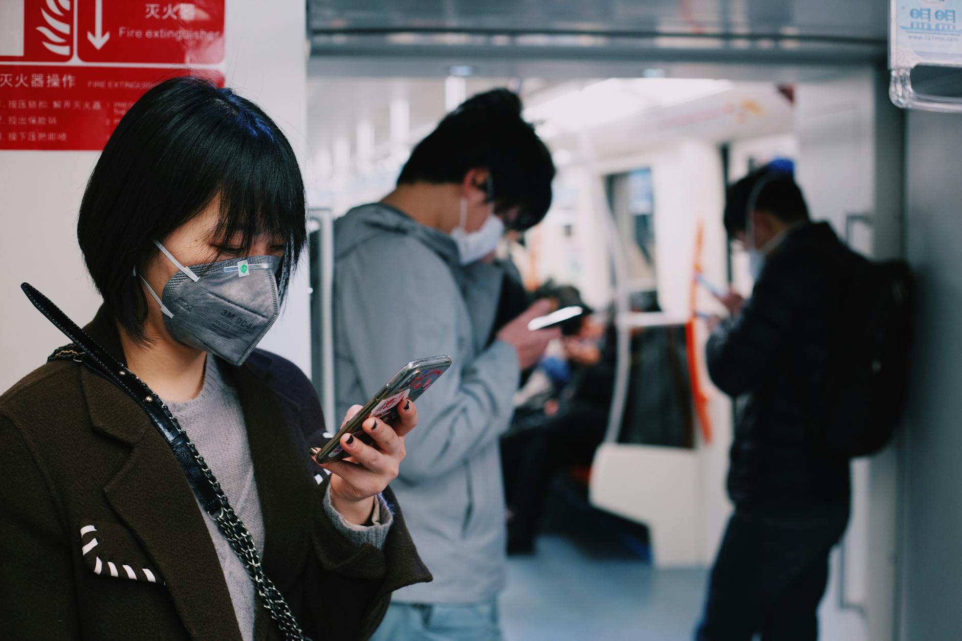 woman in black coat holding smartphone